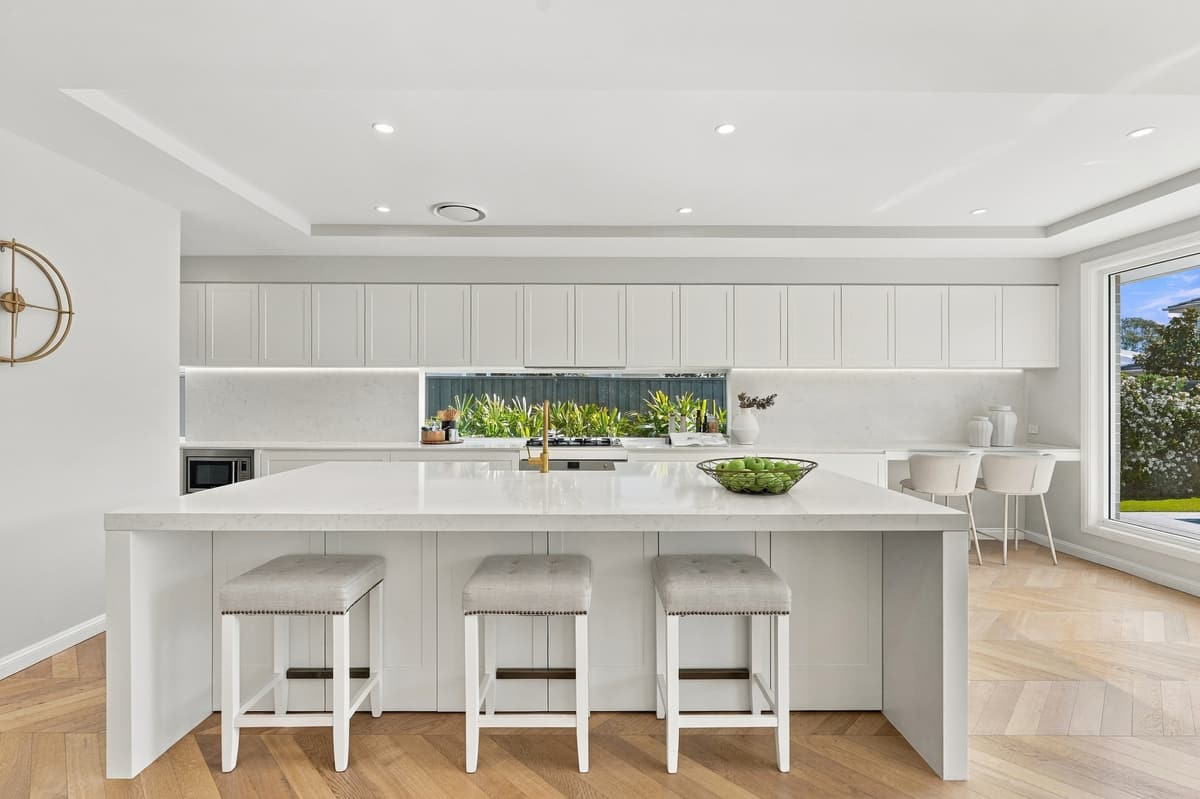 White kitchen with island bench and pendant lights